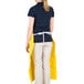 A woman wearing a yellow San Jamar dishwasher apron.