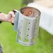 a metal cylinder with holes on it