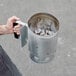 A person using an Outset briquette charcoal chimney starter to hold coals.