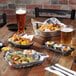 A table with a Vector metal gray wire basket filled with food and drinks.