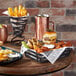 A metal gray wire basket with food on a table.