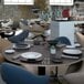 A table in a restaurant dining area set with Villeroy & Boch black shale porcelain plates.