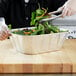 a close-up of a salad in a foil container