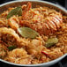 A bowl of rice with shrimp and bay leaves.