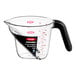 An OXO clear plastic measuring cup with a black handle.