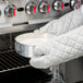 A person using a Chicago Metallic springform cake pan to bake a white cake.