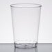 A Fineline Savvi Serve clear plastic tumbler on a white surface.