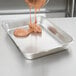 A Vollrath stainless steel roasting pan with brownie batter being poured into it.