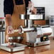 A man in an apron using a Backyard Pro electric meat grinder to make sausages.