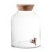 A Stylesetter clear glass beverage dispenser with a cork lid and tap.