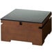 A black square induction heater with dark bamboo wooden housing on a table.