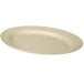 A sandstone oval platter in a white plate on a white surface.