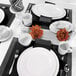 A table set with white oval melamine platters, bowls, and silverware.