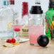 A Libbey glass filled with pink liquid and a lemon wedge on the rim.