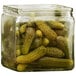A square glass jar filled with pickles.
