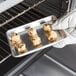A hand holding a Chicago Metallic aluminum sheet pan of cookies.
