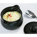 A black RAK Porcelain Chef's Fusion tureen with white liquid inside, a spoon on top.