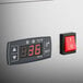 A digital temperature control panel and power switch on a refrigerated countertop bakery display case.