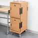 A tan plastic Cambro Ultra Camcart for food pans on wheels.