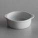 A Libbey white porcelain ramekin on a gray surface.