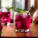 A glass of Monin Desert Pear flavored liquid with ice and a straw.