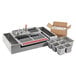 An Avantco stainless steel tray with metal containers and utensils.