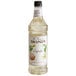 A close up of a Monin Premium Cupcake flavoring syrup bottle with a white label and brown text.