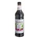 A close up of a Monin Wild Grape syrup bottle with a label.