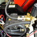 The water pump and hose of a Simpson Super Brute hot water pressure washer.