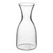 A clear Libbey Tritan plastic carafe with a small amount of liquid in it.