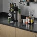 A clear vinyl countertop mat on a kitchen counter with a white and green cup.