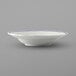 A close up of a Tuxton white china soup bowl with a blue rim.