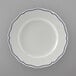 A Tuxton white china plate with scalloped edges and blue trim.