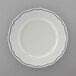 A Tuxton white china plate with scalloped edges and blue trim.