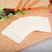 A cutting board with sliced Cooper sharp white American cheese, bread, and lettuce.