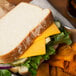 A plate with a sandwich made with Great Lakes Mild Cheddar cheese slices.