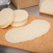 A stack of Great Lakes Provolone cheese slices on a cutting board.