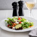 A plate of salad with feta cheese on a table.