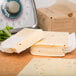 A stack of Great Lakes Pepper Jack Cheese slices on a table with a scale.