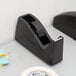 A black Shurtape 3" masking tape dispenser on a white desk.