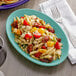 An Island Blue Tuxton oval china platter with a plate of pasta, tomatoes, and chicken.