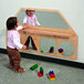 A young girl playing with blocks in front of a Whitney Brothers wall mirror.