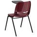 A red plastic Flash Furniture chair with a black desk.