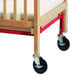 A wooden crib evacuation brace with black wheels.