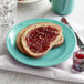 A Tuxton Concentrix Island Blue china plate with a piece of bread and jam on it.