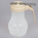 A plastic Tablecraft syrup container with a handle.