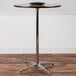 A Flash Furniture round birchwood cocktail table with a black bowl on top.