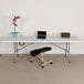 A white Flash Furniture rectangular bi-fold plastic folding table with a laptop on it.