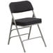 A black folding chair with a black pin-dot fabric seat.