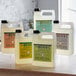 A group of white plastic bottles of Mrs. Meyer's Basil Scented Hand Soap.